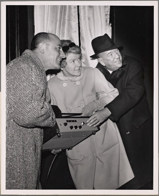 Elaine Stritch, Noël Coward, and restaurant owner Vincent Sardi in a promotional photograph in which they are pictured lighting the new electronic billboard for the original Broadway production of "Sail Away"