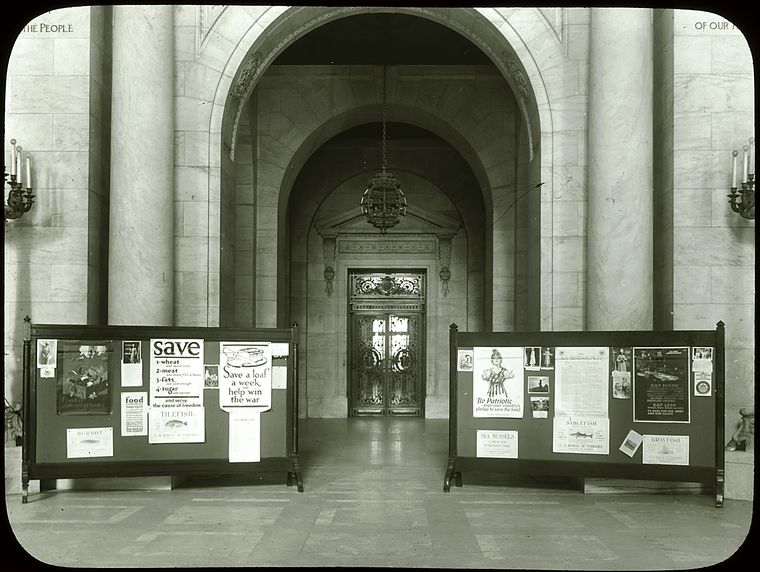 Central building, first floor lobby : looking from lobby (Astor Hall) toward exhibition hall, war posters (?) displayed on either side, ca. 1918
