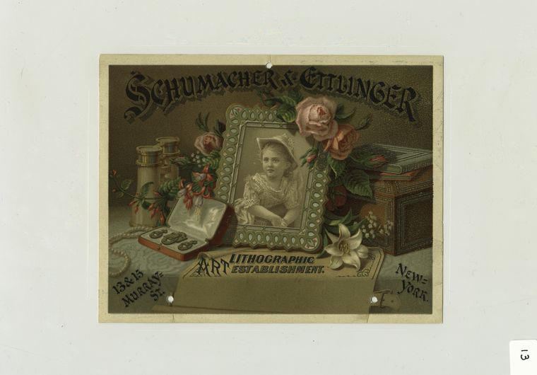 [A trade card with the text : Schumacher & Ettlinger art lithographment, 13 & 15 Murray St., New York; depicting a table spread with binoculars, a picture of a girl in a frame, jewelry, flowers, boxes and books.]