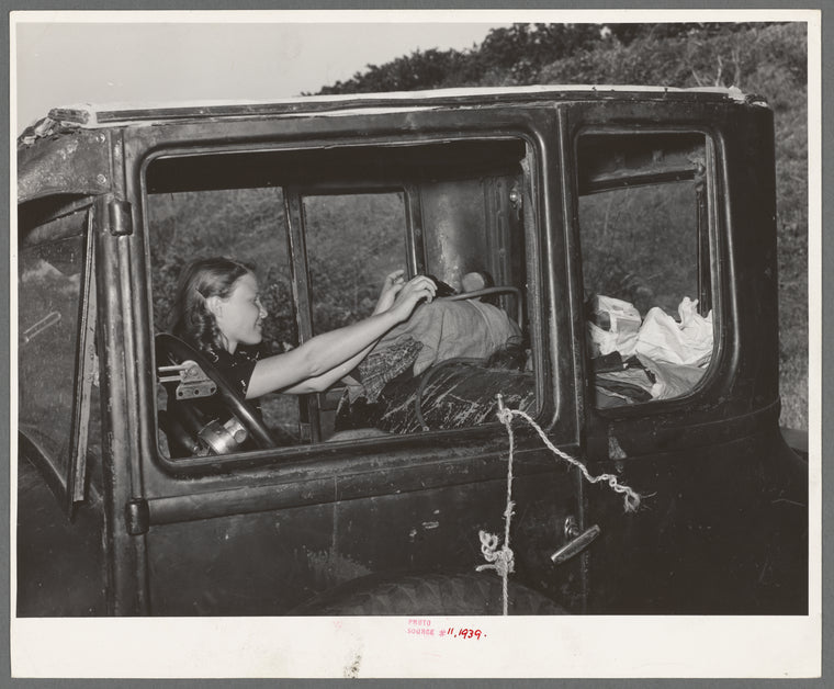 Migrant woman reaching in automobile for supplies while camped near Prague, Oklahoma. Lincoln County, Oklahoma