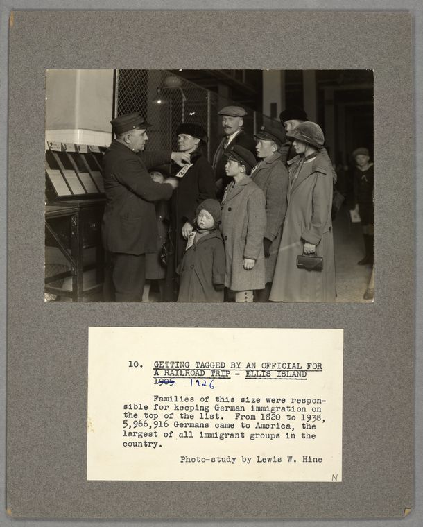 Getting tagged by an official for a railroad trip, Ellis Island, 1905