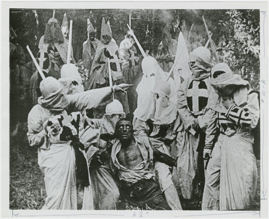 Klansmen surround freedman Gus (played by white actor Walter Long in blackface) in a scene"The Birth of a Nation."
