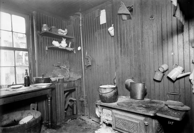 Kitchen with stove, sink and utensils.