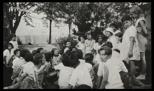 Work with schools : story hour in the open, librarian and children in park, ca. 1920s