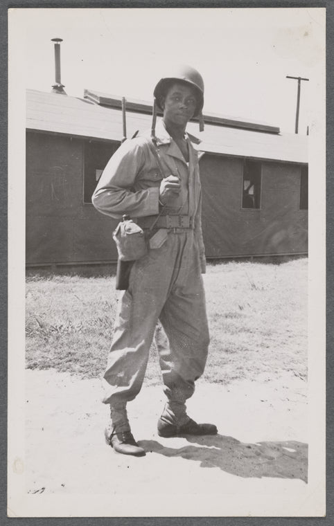 Man in uniform standing with rifle over shoulder