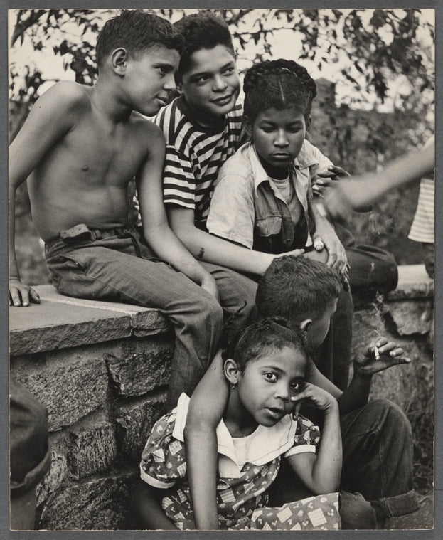 Group of young kids seated outside embracing