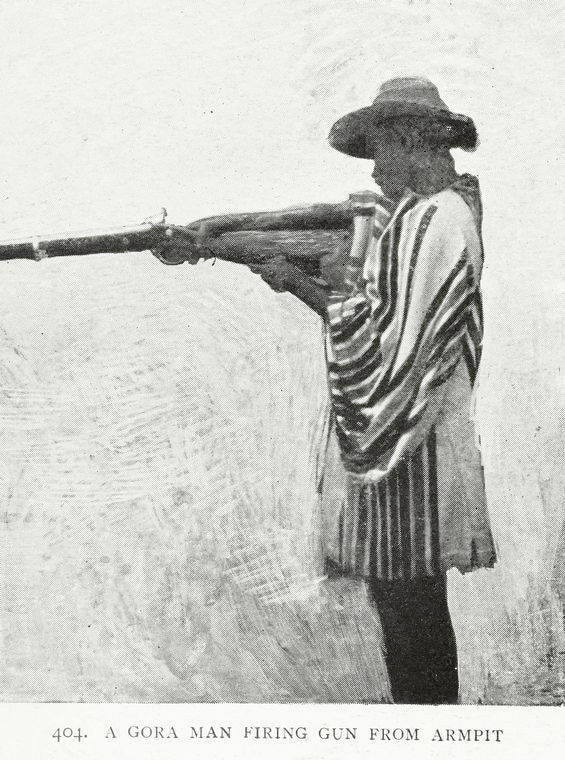 A Gora man firing gun from armpit.