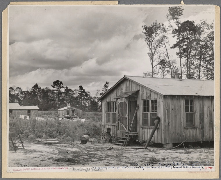 Temporary shacks for settlers dwelling near houses on Wolf Creek Farms, Georgia