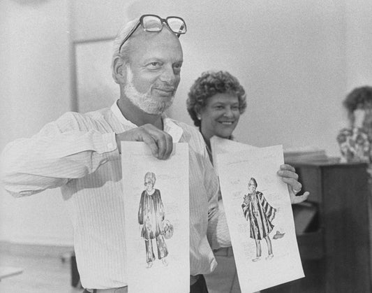 Director Harold Prince holding up renderings of costumes that would eventually be scrapped during a rehearsal of the Broadway production of the musical "Merrily We Roll Along".