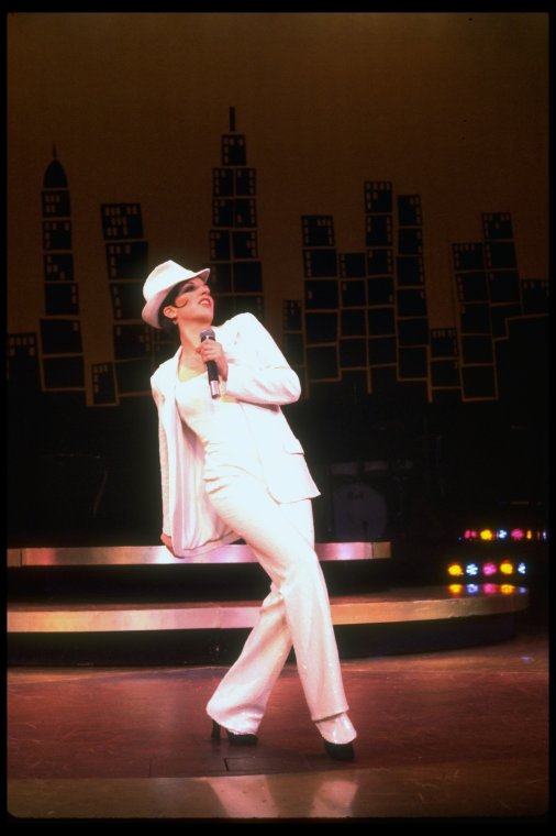 Actress Liza Minnelli wearing a white suit w. a fedora designed by Halston in a scene from the Broadway production of the musical "The Act." (New York)