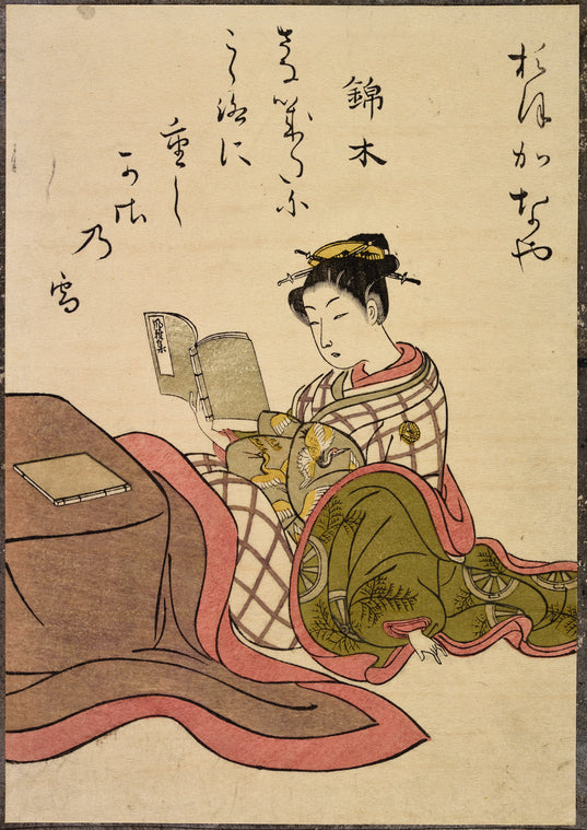 Seated lady reading book, second book on covered table