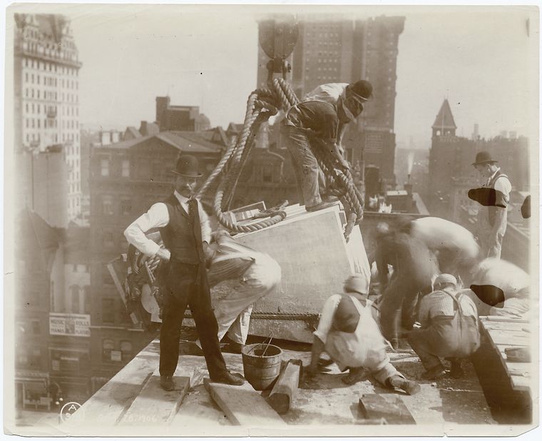 Exterior marble work : construction workers positioning a piece of marble on the roof, looking east