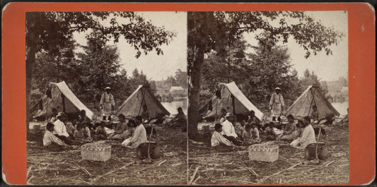Group of people, including children, with two tents and a woven basket.